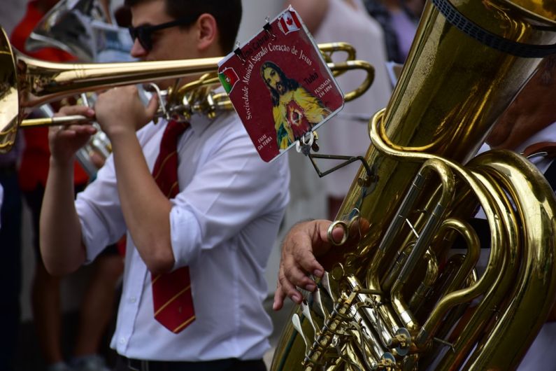 Music Artists - a man in a white shirt and tie playing a trumpet