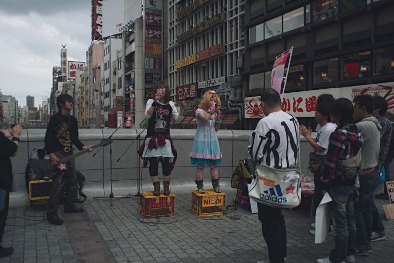 Japanese Musicians - man and woman standing on sidewalk during daytime