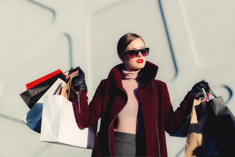 Fashion - photo of woman holding white and black paper bags