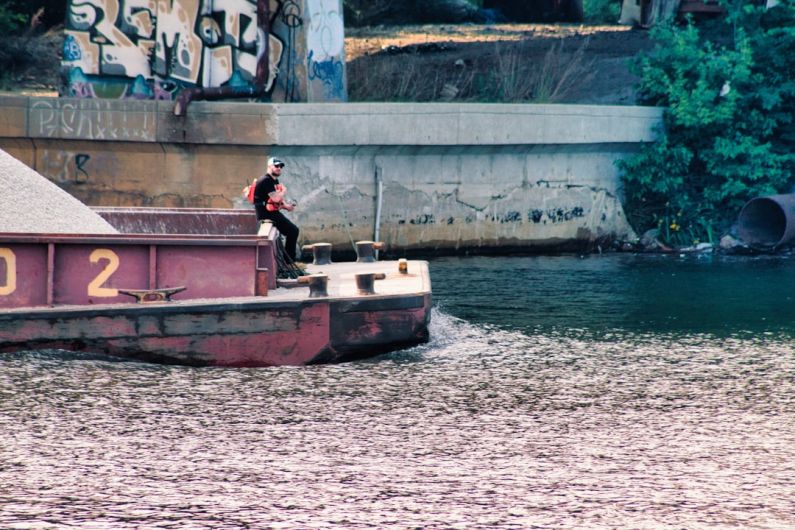 Transportation Technology - a man riding on the back of a boat in the water