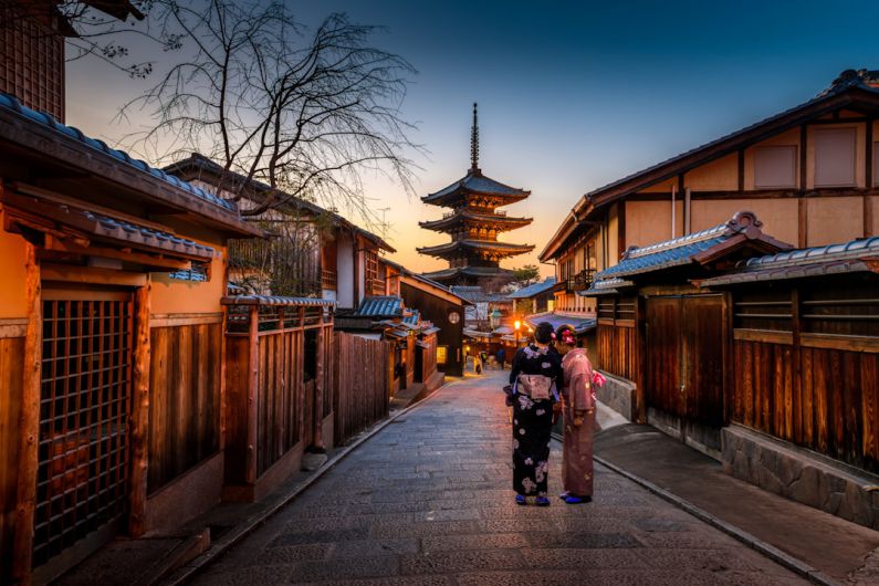 Japanese Culture - two women in purple and pink kimono standing on street